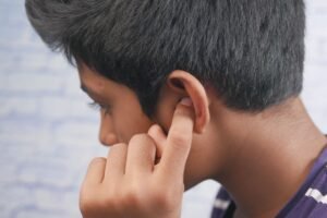 a boy covering his ear